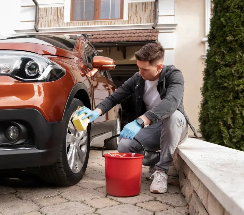 Lavage auto à domicile Vailhourles : professionnel intervenant sur un véhicule